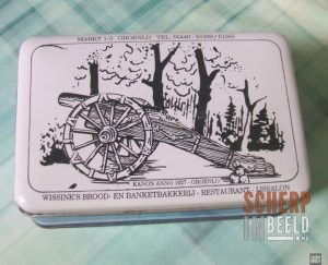 Memorabillia uit Groenlo: Koekjestrommel van Wissink met afbeelding van kanon.